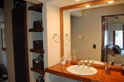 een badkamer met een wastafel en een grote spiegel bij Orillas del Gutierrez in Bariloche