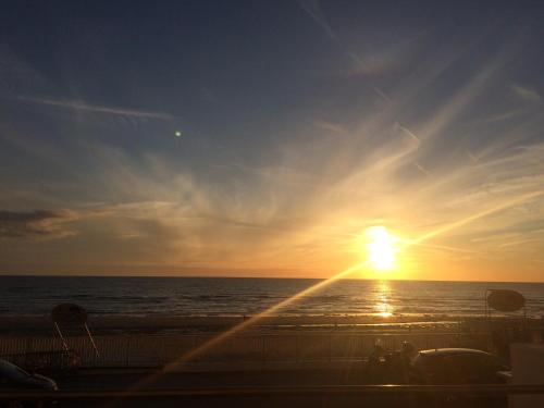 a sunset on the beach with the ocean in the background at Les Chambres d'Hôtes de la Mer in Merlimont