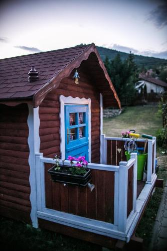 a small house with a blue window and a fence at Sólyomvár-Lak in Komlóska