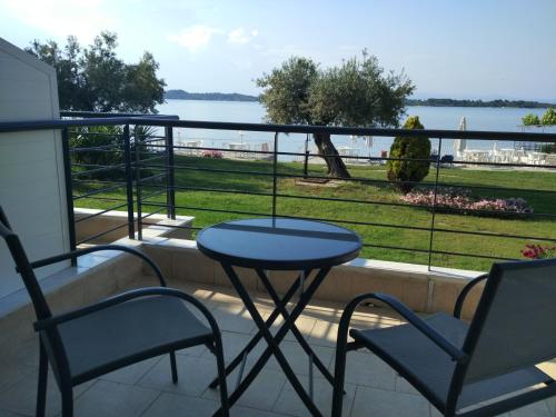 a table and chairs on a balcony with a view of the water at Vourvourou Hotel in Vourvourou