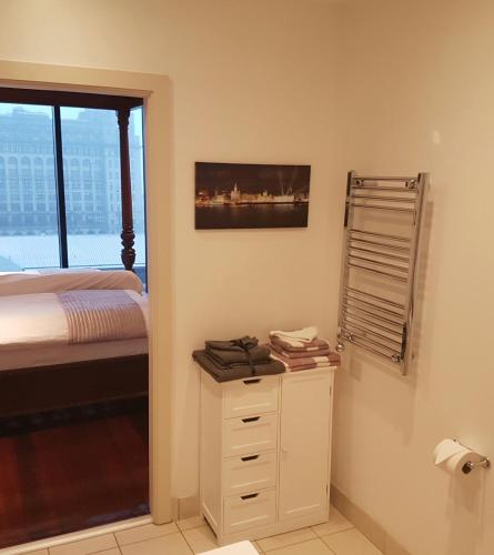 a bedroom with a bed and a dresser and a window at Excelsior Apartments - Liverpool Central - Free Parking - AirCon in Liverpool