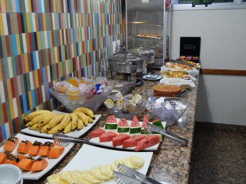 a buffet with many different types of food on a counter at Frimas Hotel in Belo Horizonte