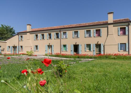 a large building with red flowers in front of it at B&B Corte Vignazza in Rovigo