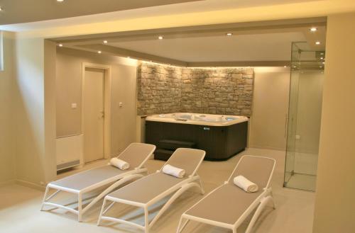 a bathroom with two chairs and a bath tub at Villa Banic in Bartolići