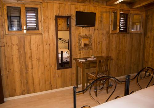 una camera con letto, tavolo e specchio di Salento Casevecchie a Sogliano Cavour