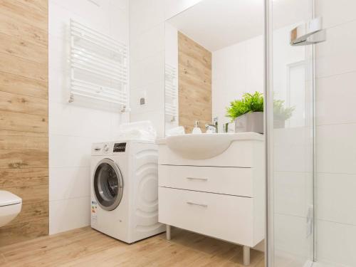 a bathroom with a washing machine and a sink at VacationClub - Solna Apartment C103 in Kołobrzeg