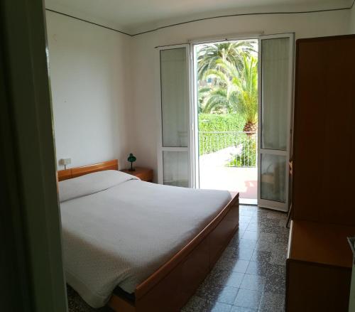 ボルジョ・ヴェレッツィにあるAlbergo Calcagnoのベッドルーム1室(ベッド1台付)、スライド式ガラスドアが備わります。