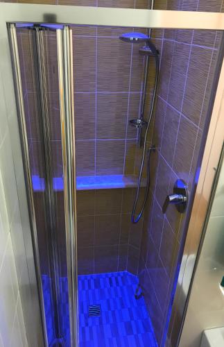 a bathroom with a shower with a blue tile floor at Hotel Vienna in Senigallia