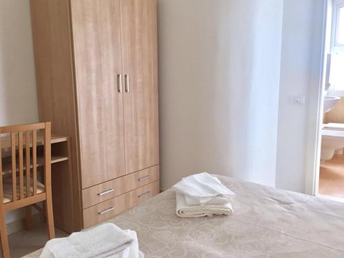 a bedroom with a bed and a wooden cabinet at Hotel Madrid in Riccione