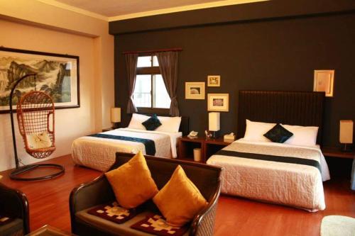 ein Hotelzimmer mit 2 Betten und einem Sofa in der Unterkunft Hua Qing Yuan in Yuanshan