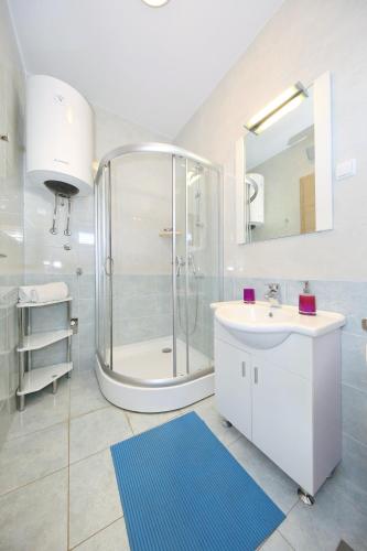 a bathroom with a shower and a sink and a mirror at Be-Bu-Mar Apartments in Sveti Filip i Jakov