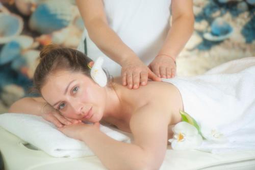 a woman getting a massage in a bath tub at SeaPark Hotel Wellness & Spa in Kołobrzeg