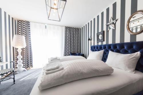 a bedroom with a blue and white striped wall at City Stay Vienna – Lugeck in Vienna