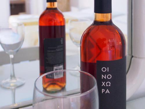 two bottles of wine and a glass on a table at Villa Markos in Perissa