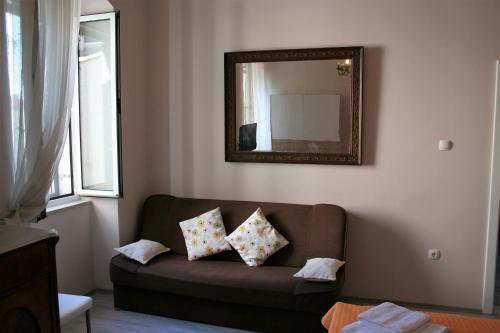 a living room with a brown couch and a mirror at Pavelin apartments in Split