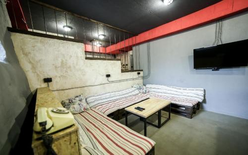 リヴィウにあるLviv Loft Prisonのテーブルとテレビ付きの客室内のベッド2台