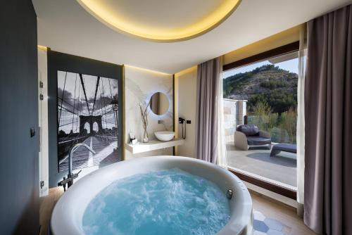 a bath tub in a bathroom with a large window at Hotel Spa Elia in Alcalá del Júcar