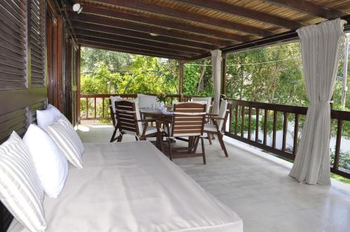 a porch with a bed and a table and chairs at Ava Apartments in Agios Gordios