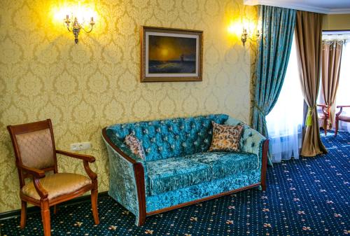 a living room with a blue couch and a chair at Sobranie hotel in Volgograd