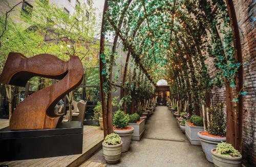ニューヨークにあるノモ ソーホーの鉢植えの植物や木々が生い茂る温室