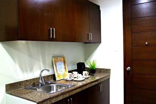 a kitchen with a sink and a counter top at Food District Hostel - Ortigas Kapitolyo in Manila