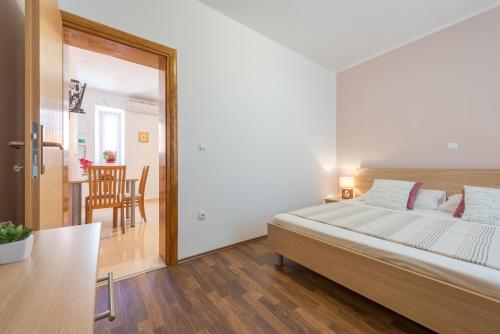 a bedroom with a bed and a dining room at Fora Apartments in Dubrovnik