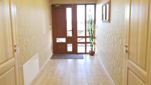 a hallway with a door and a tile floor at Irmos Apartamentai salia Klaipedos in Toleikiai