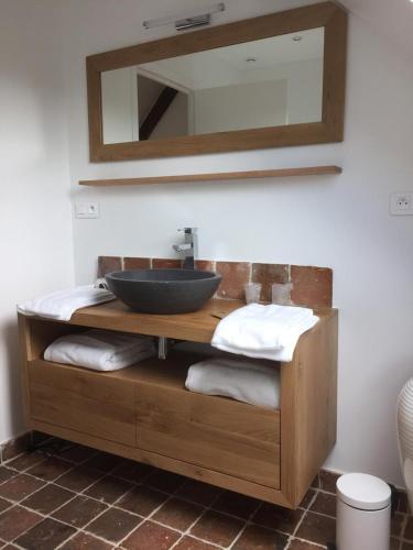 a bathroom with a sink and a mirror and towels at l'Escale de Broglie in Broglie
