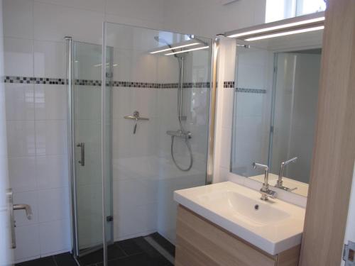 a bathroom with a sink and a glass shower at La Tulipe in Egmond aan den Hoef