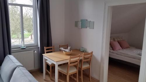 uma sala de jantar com uma mesa e cadeiras e uma cama em Ferienwohnung Parkblick em Soltau