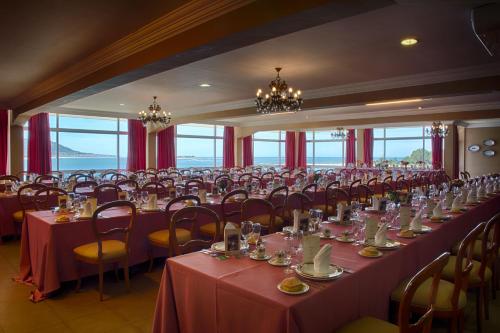 a large room with tables and chairs with red tablecloths at Hotel El Molino in A Guarda