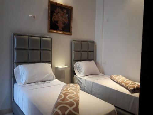 Cette chambre comprend 2 lits et une photo murale. dans l'établissement Horizon Home, à Casablanca