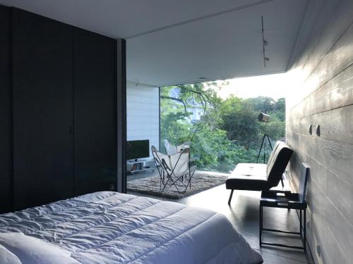 une chambre avec un lit, un bureau et une fenêtre dans l'établissement Le studio Florent, à Lannion