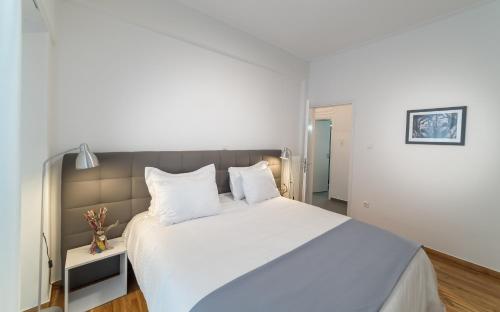 雅典的住宿－近雅典衛城的現代化設計公寓，卧室配有白色大床和白色枕头