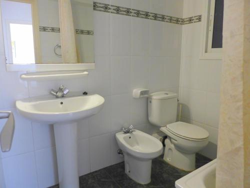 Baño blanco con lavabo y aseo en CYE 5 Rentalmar, en La Pineda