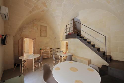 a room with a table and chairs and a staircase at B&B Kabala in Lecce