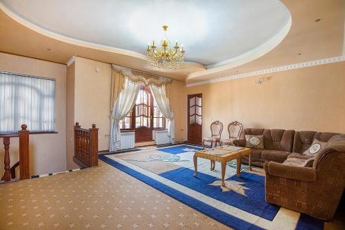 uma sala de estar com um sofá e uma mesa em Green House Hostel em Dushanbe