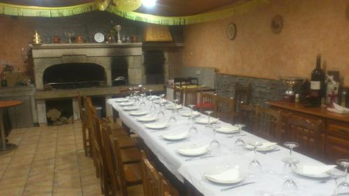 una mesa larga con platos blancos y copas de vino en Casa Alonso, en Narón