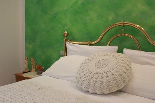 una camera da letto con parete verde e un letto con cuscini bianchi di Terrazza sul Mare a Fano