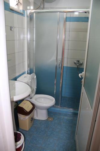 a bathroom with a shower and a toilet and a sink at Olive Tree Apartment in Sarandë