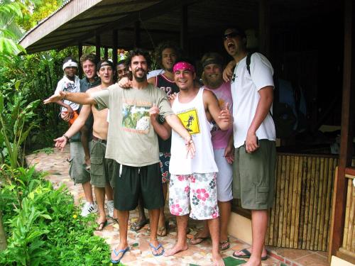 a group of men standing outside of a house at La Casa de Rolando in Puerto Viejo
