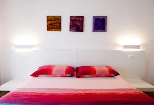 
a bedroom with two beds and a lamp on the wall at Daniela B&B Fiera in Pero
