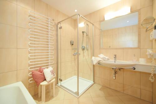 a bathroom with a shower and a sink at Hotel Tirolerhof in Flachau