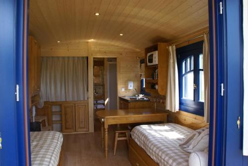 - une chambre avec 2 lits et un bureau dans l'établissement La Roulotte du Domaine de Meigné, à Meigné