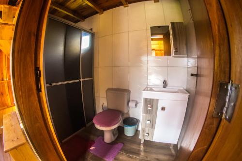 a small bathroom with a toilet and a sink at Chalés Vista Bonita in Urubici