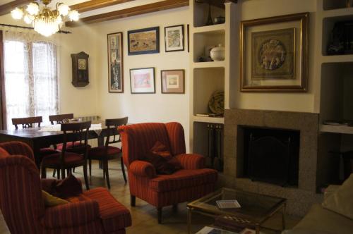 a living room with a fireplace and a table and chairs at Ca la Magda in Camarasa