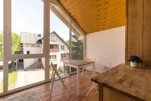 Una habitación con una mesa y una ventana grande. en Saulės Namai, en Palanga