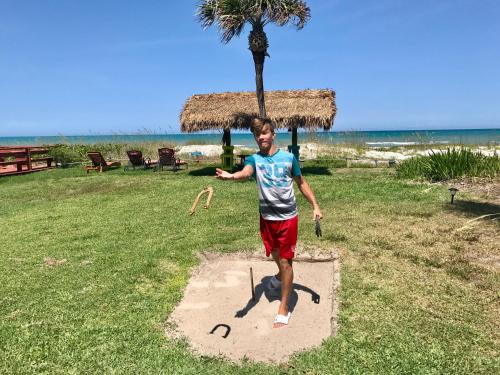 a man is standing on a patch of sand on the beach at South Beach Inn - Cocoa Beach in Cocoa Beach