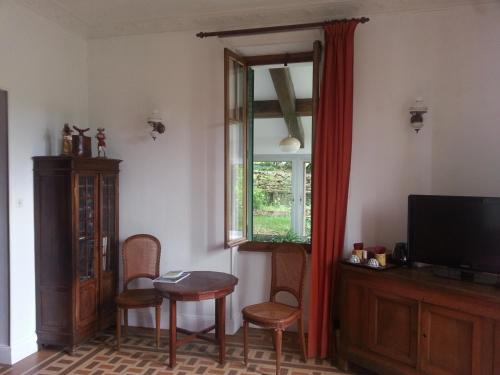 salon z telewizorem, stołem i krzesłami w obiekcie Belle chambre dans maison atypique w mieście Joyeuse