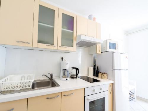 a kitchen with a sink and a refrigerator at Apartments Laura in Korčula